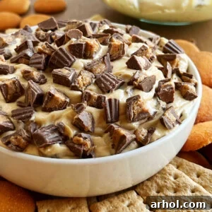 bowl of peanut butter cheesecake dip with mini Reese's cups on top