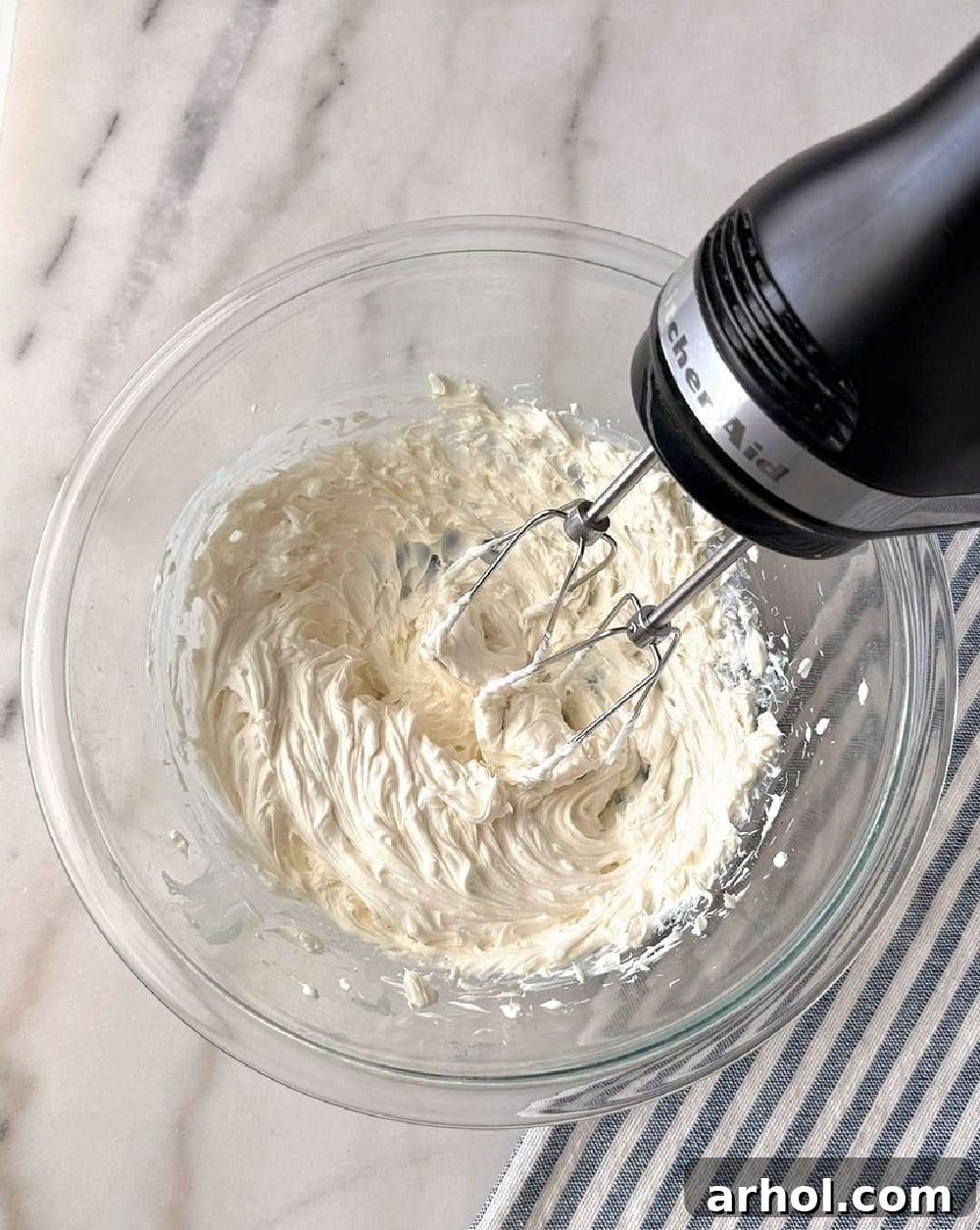 mixing cream cheese with electric mixer.