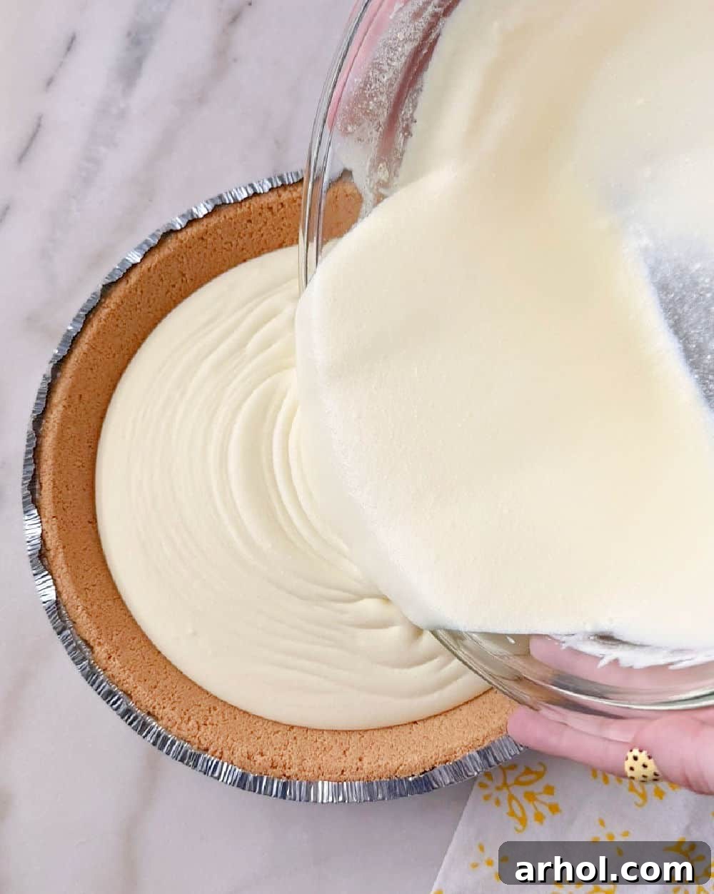 No-Bake Creamy Lemon Jello Pie 8 Pouring lemon filling into a graham cracker crust.