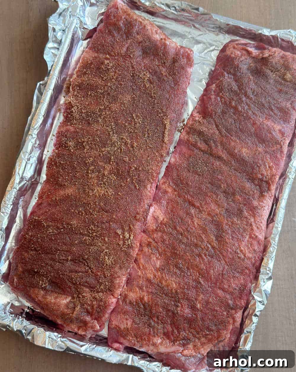 spice rubbed ribs on foil lined baking sheet.