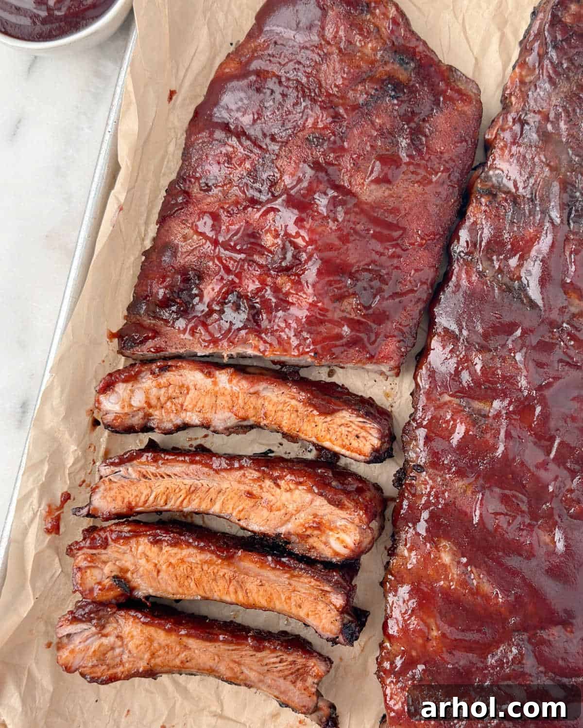 baked and sliced st louis style ribs with BBQ sauce.