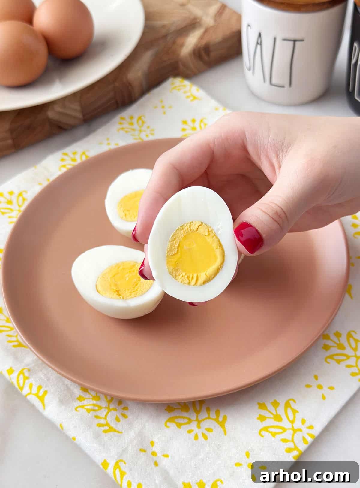 holding sliced hard boiled egg in hand.