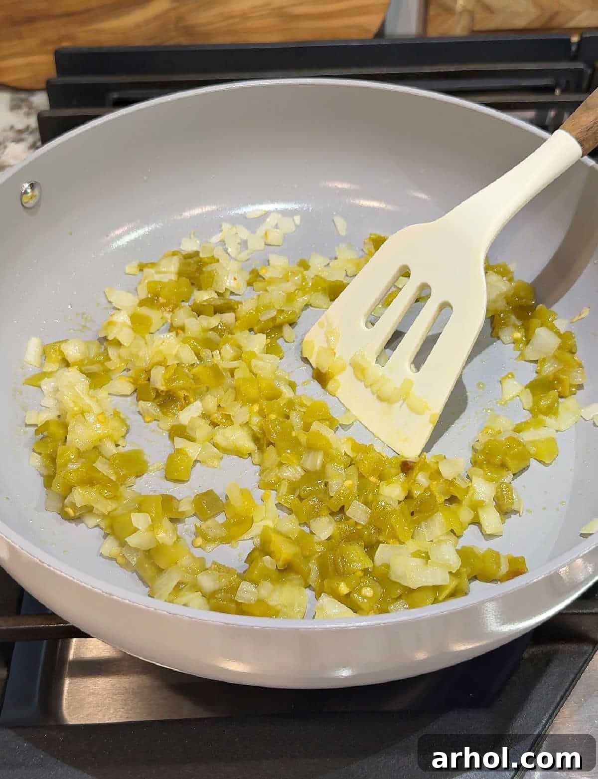 cooking onion and green chiles in pan.