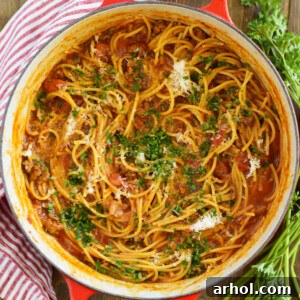 one-pot spaghetti and meat sauce with parsley in red Le Creuset Dutch oven