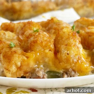 cheesy tater tot casserole with hamburger meat and melted cheese on a plate