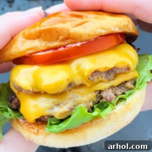 double smash burger with cheese in hand.