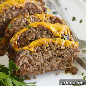 cheesy bbq meatloaf slices with melted cheddar cheese on a white platter