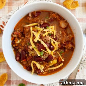 best chili recipe with ground beef and kidney beans cooked on stovetop in white bowl