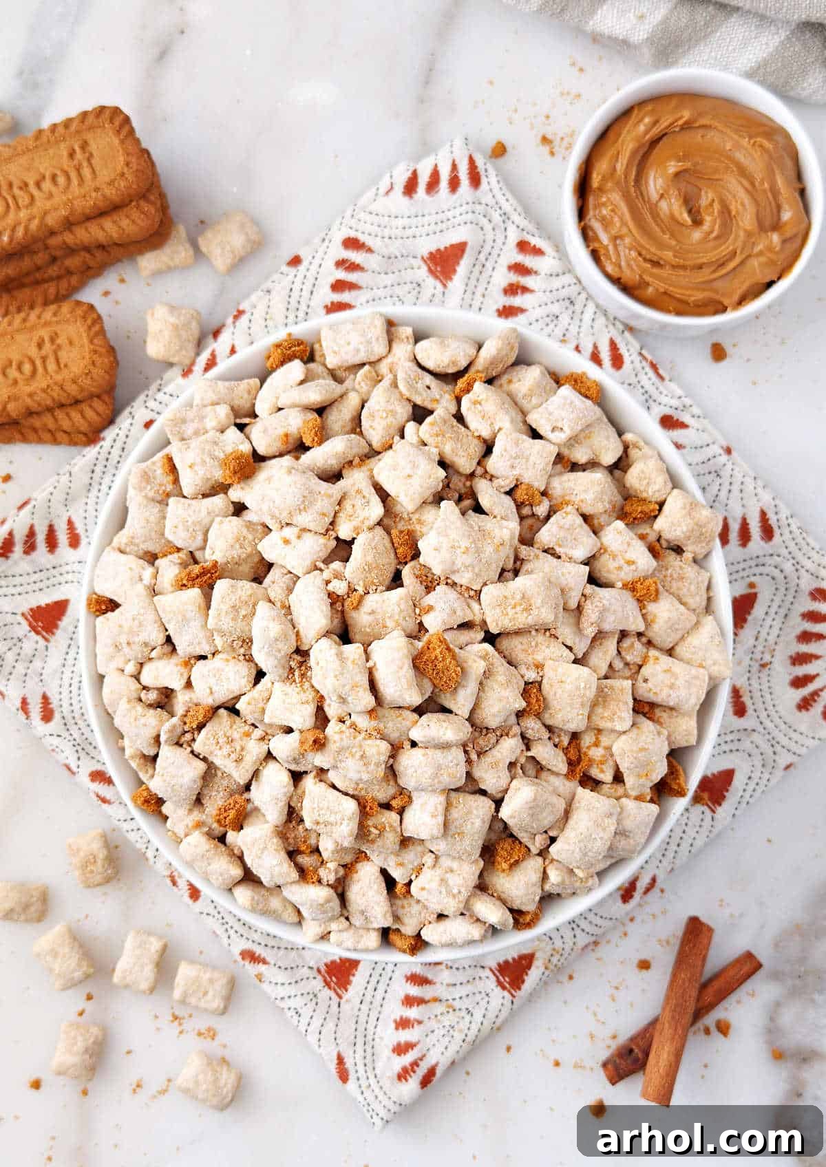bowl of cookie butter puppy chow with Biscoff cookies and spread.