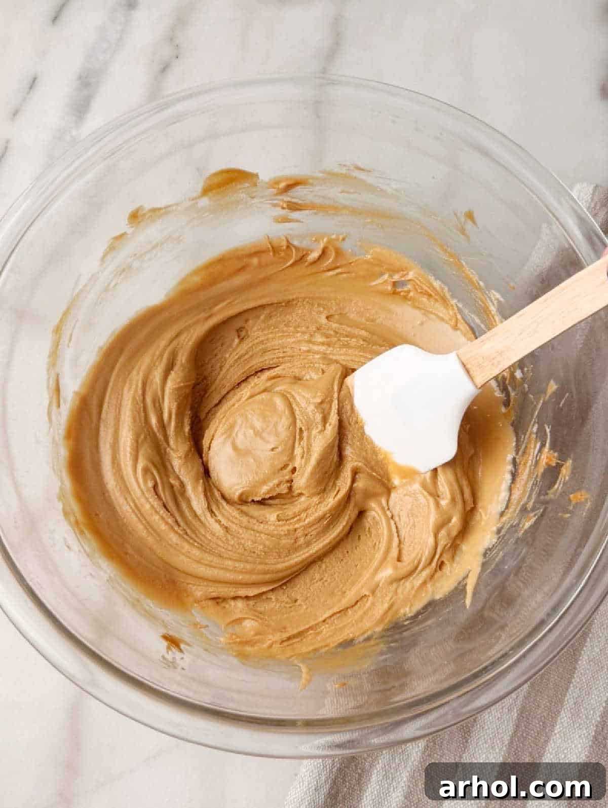 stirring cookie butter mixture with spatula.