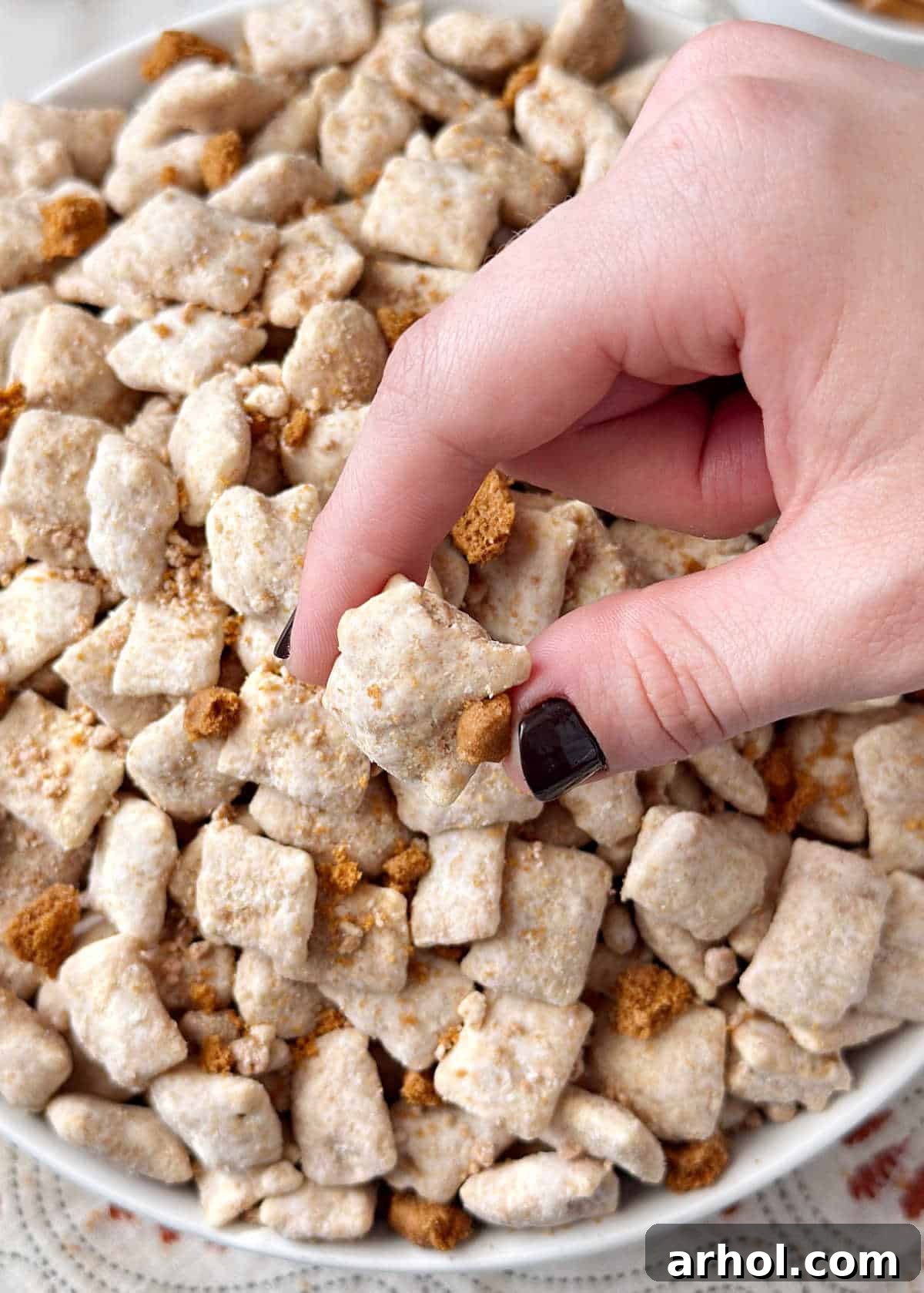 Biscoff puppy chow in hand.