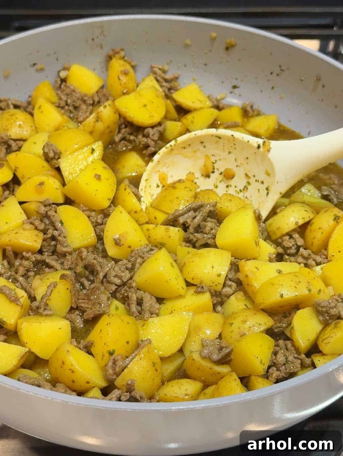 stirring meat and potatoes.