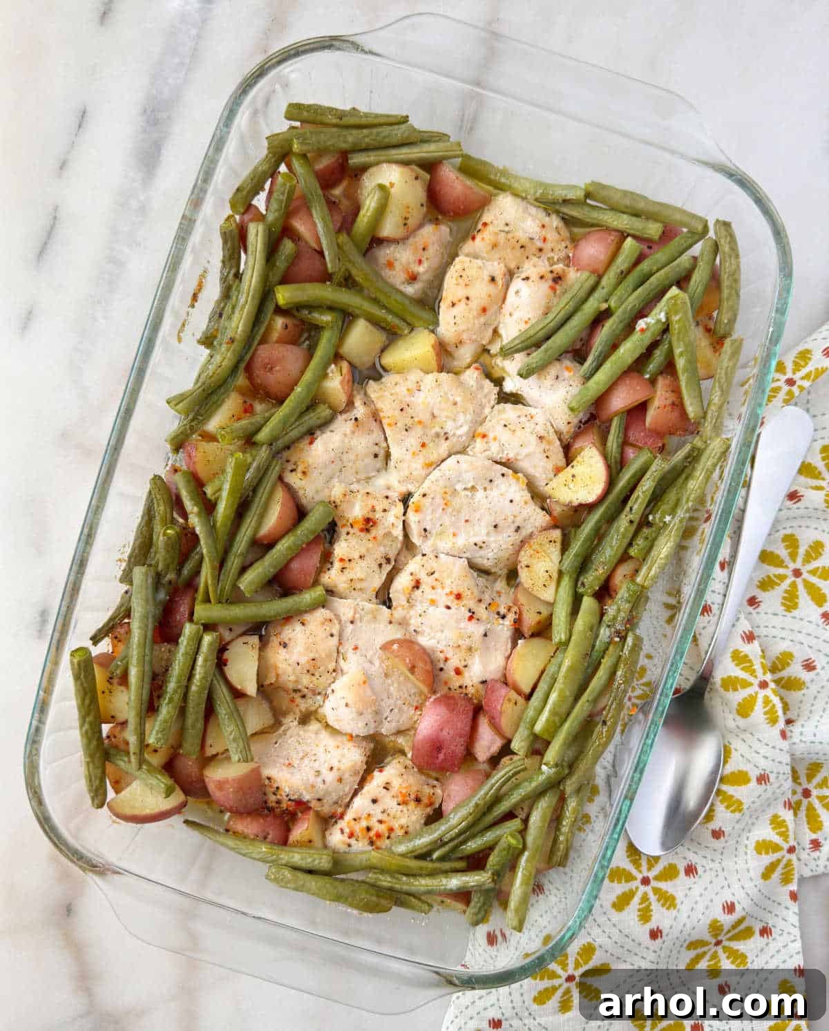 chicken, green beans, red potatoes with Italian dressing in baking dish.
