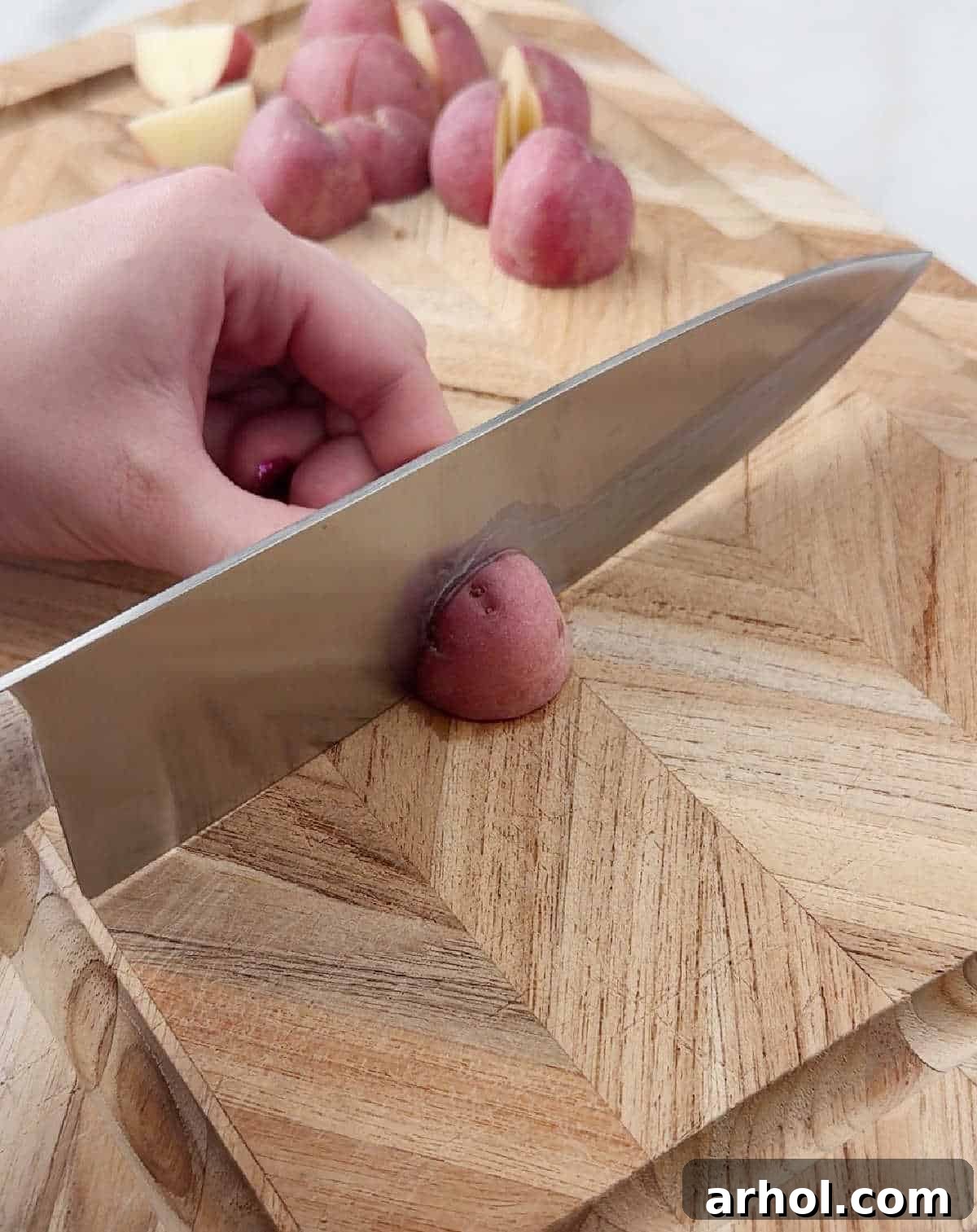 slicing red potatoes on cutting board.