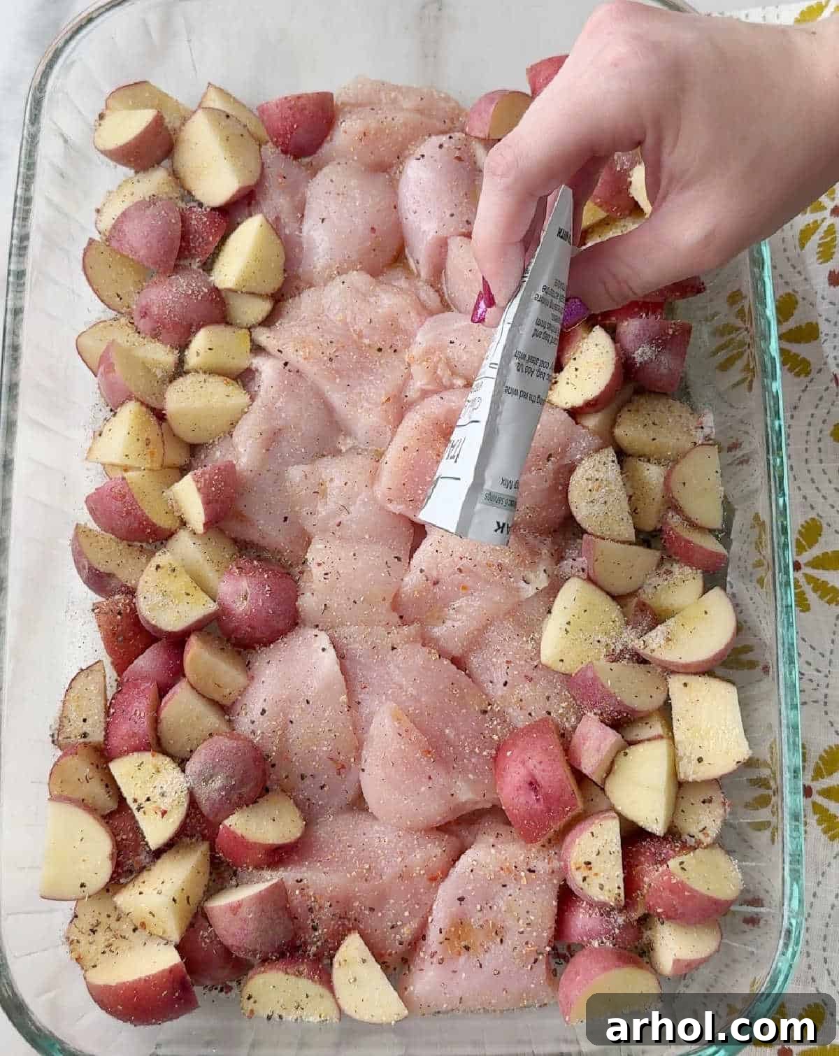 sprinkling seasoning packet over food.