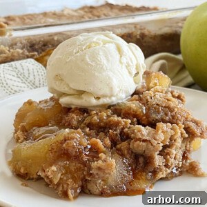 apple pie dump cake with scoop of vanilla ice cream and caramel sauce on a plate
