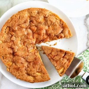 fresh apple cake with slice on cake server.