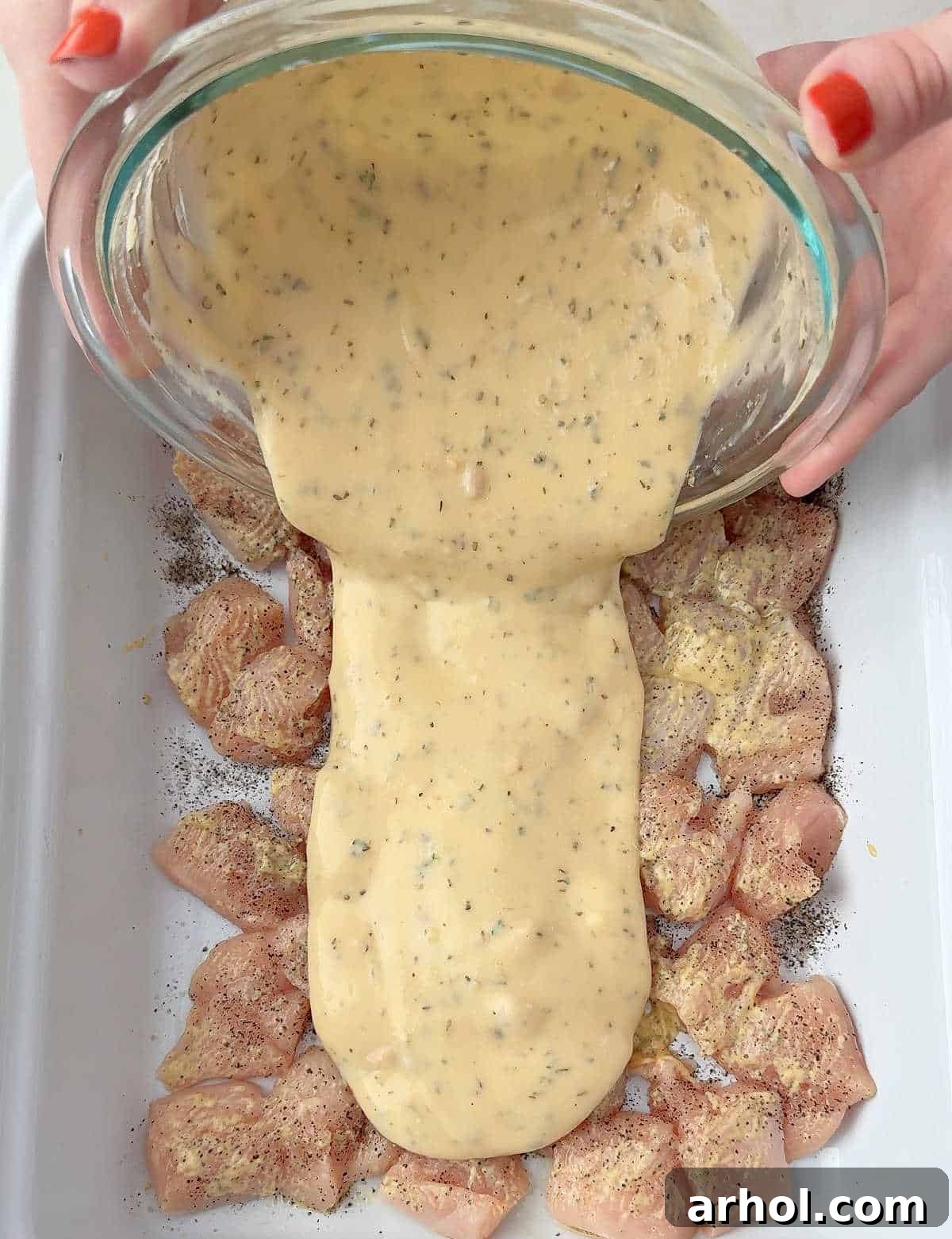 pouring sauce over chicken.