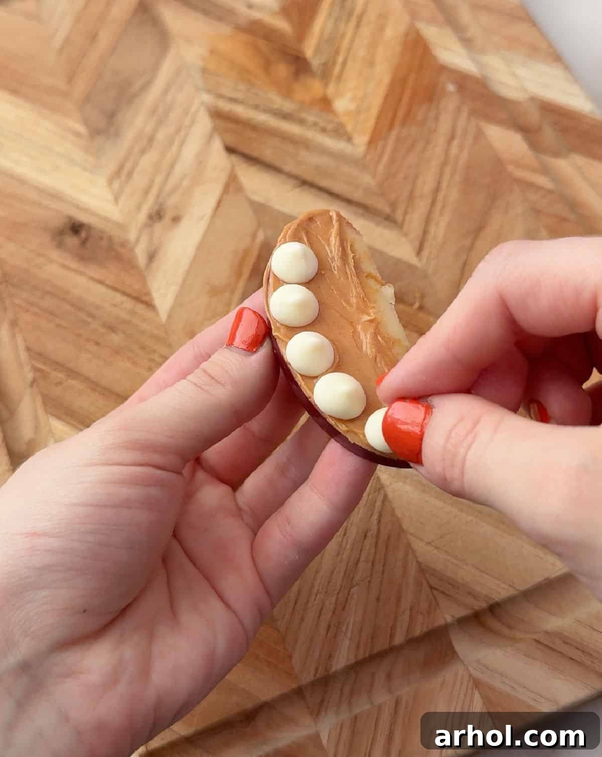 placing white chocolate chips on apple.