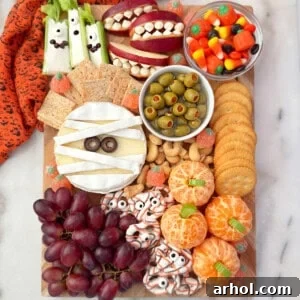 Halloween charcuterie board recipe with fruits, cheese, veggies and candy.