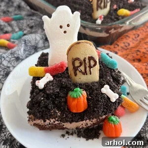 halloween dirt cake with crushed oreos, gummy worms, milano cookies and ghost on a plate