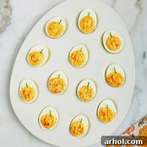 pumpkin deviled eggs in serving dish.